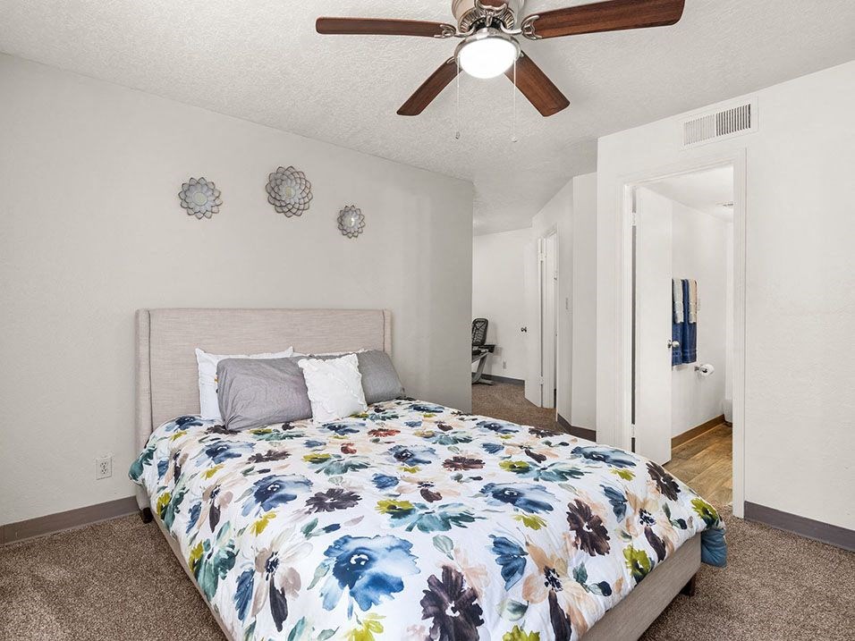 a bedroom with a bed and a ceiling fan